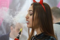 Девушка парит вейп на выставке Vapexpo 2018