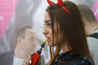 Девушка парит вейп на выставке Vapexpo 2018