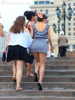 девушка поднимается по лестнице в мини платье