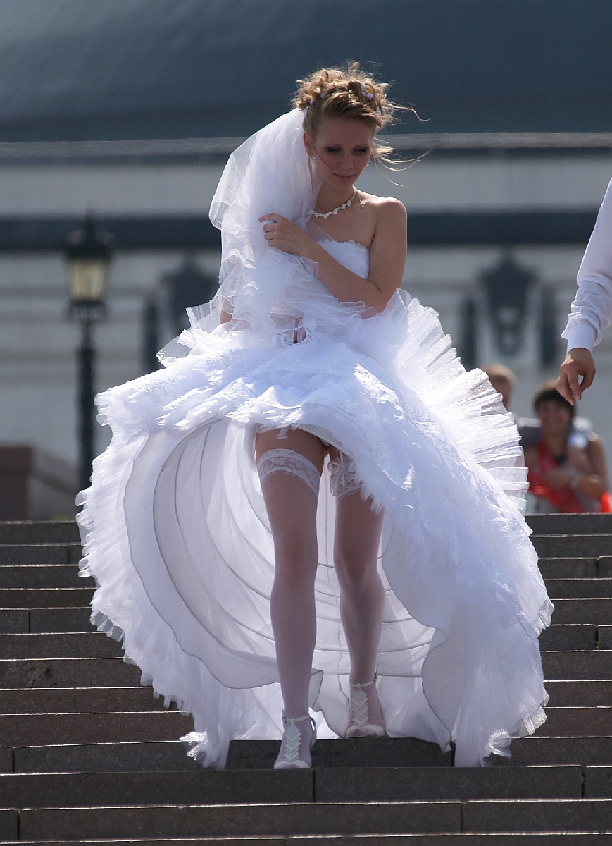 ветер поднимает подол невесты в чулках на каблуках
