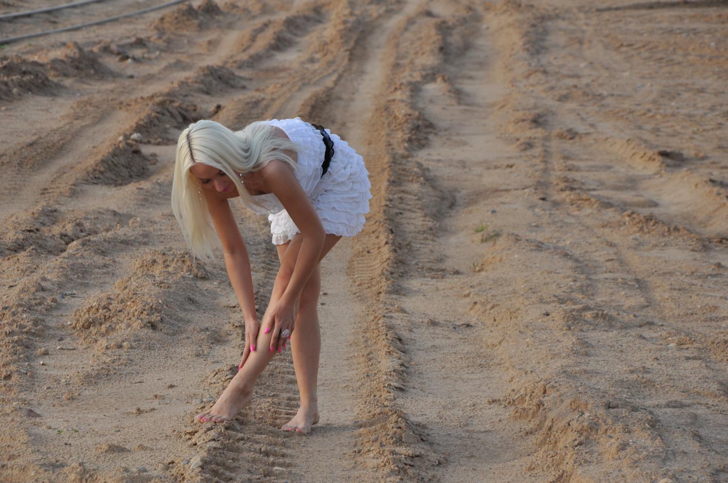 Девушка в коротком платье на песке