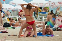 девушка на пляже танцует в купальнике