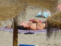 Девушка загорает на пляже топлес