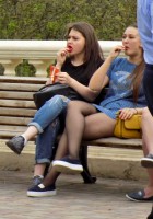 Три девушки едят мороженое на скамейке